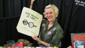 Cici James, Owner of Singularity & Co. poses with a fabric bag she designed with inspiration from the Twilight Zone.